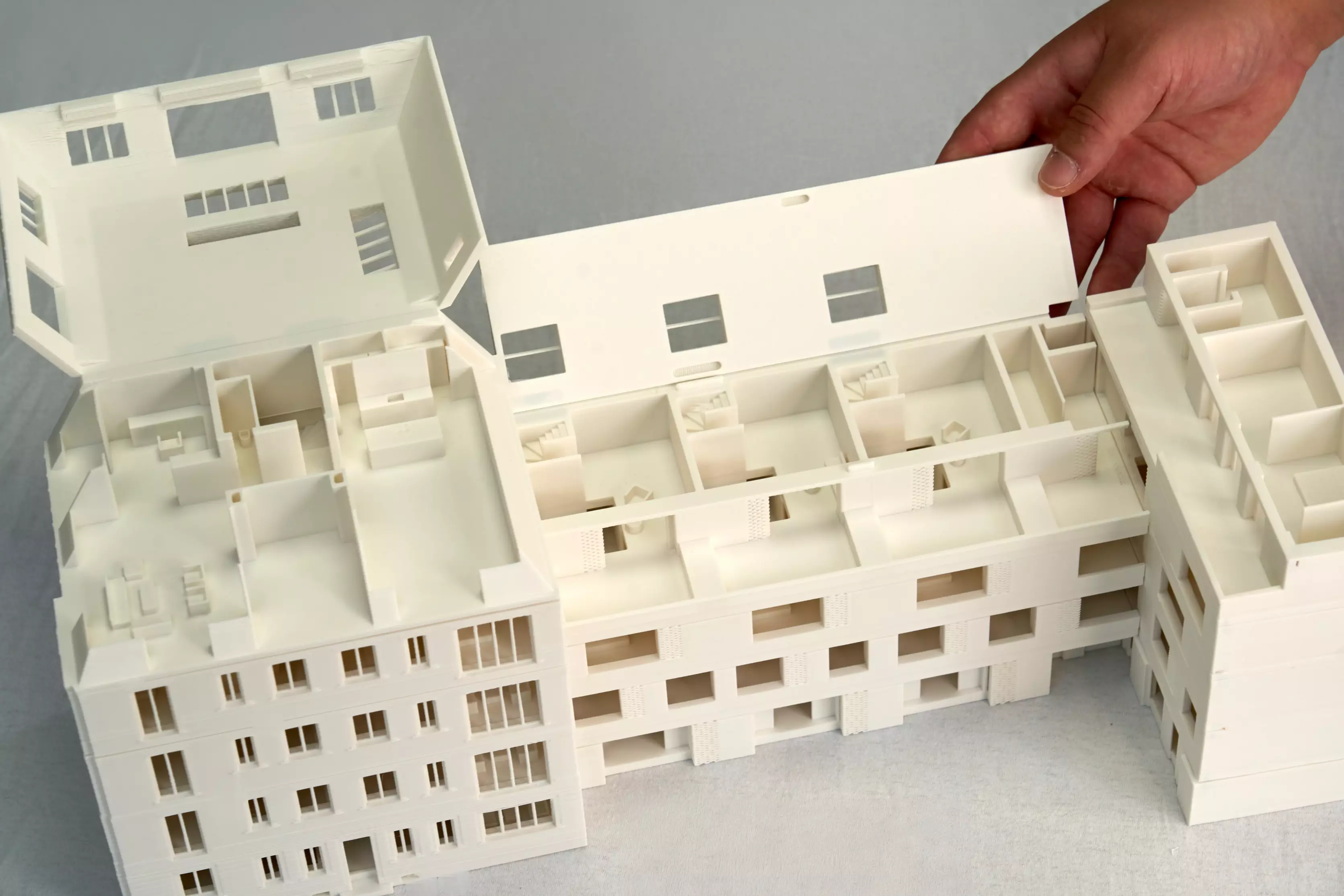 3D-gedrucktes Modell eines modularen Wohnblocks in München, aus der Vogelperspektive mit aufgeklapptem Dach zur Einsicht in das Innere